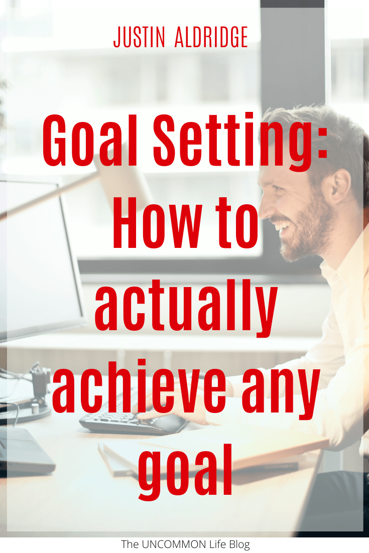 Man typing on a computer in the background behind text that says "Goal Setting: How to actually achieve any goal" in red font
