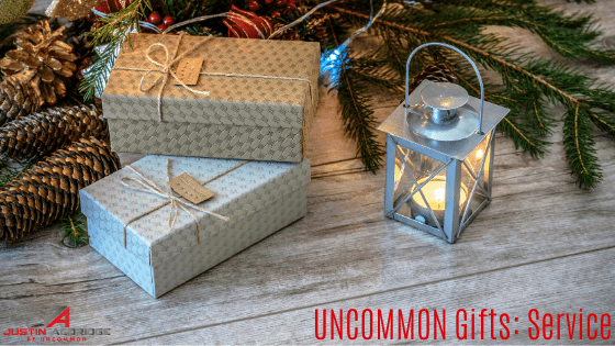 Beautifully wrapped gifts stacked under a Christmas tree with the words "UNCOMMON Gifts: Service" written in red.