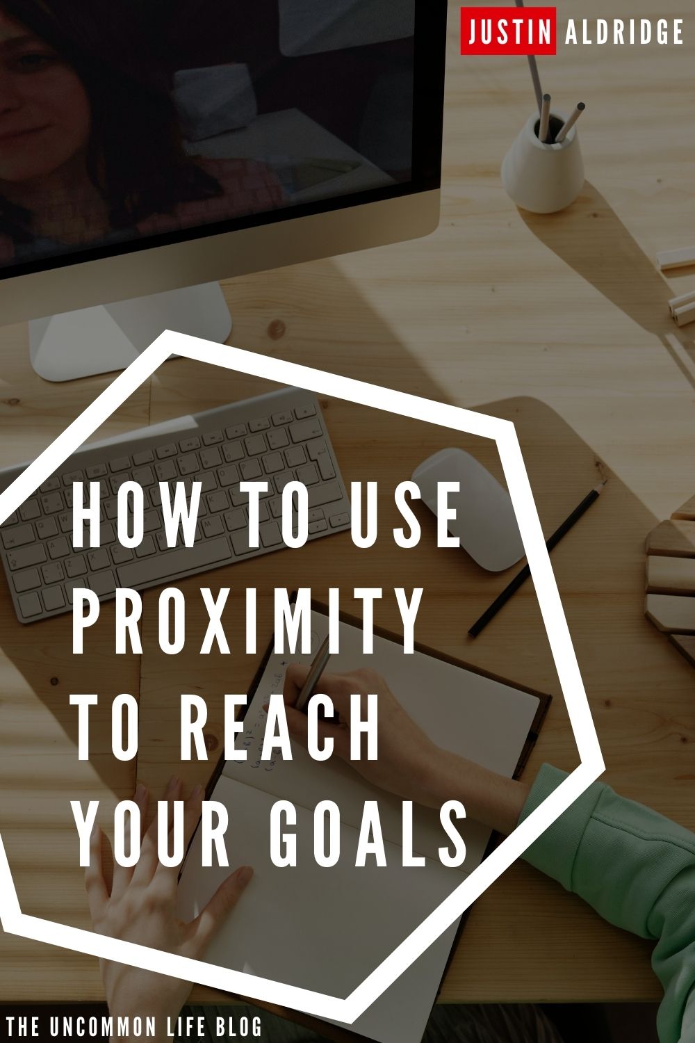 Overhead picture of a person writing on a pad on a desk in the background behind the text, "How to use proximity to reach your goals"
